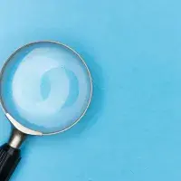 Una lupa sobre fondo celeste.